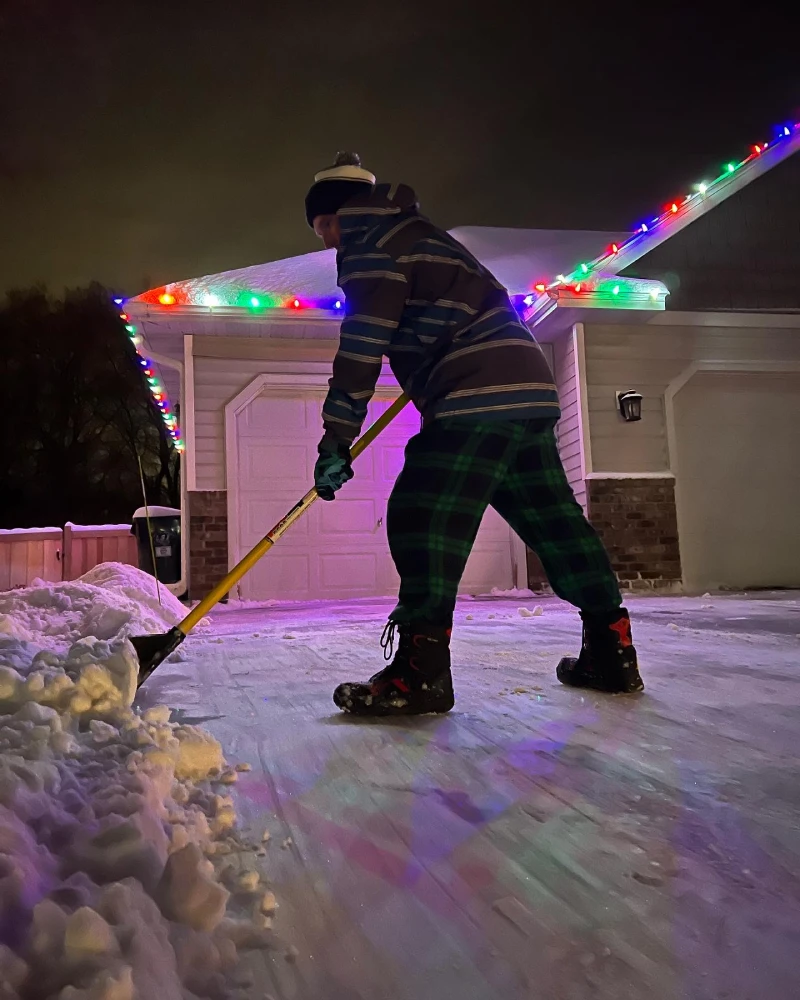 professional removing snow in front of home